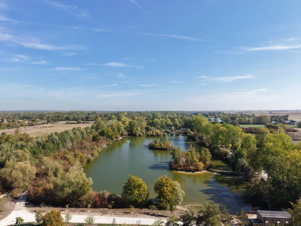 L'étang Idylle et ses deux îlots boisés, niché dans la verdure.