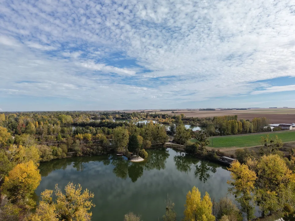 L'étang Arôme et sa presqu'île au saule pleureur, avec l'Écolodge sur sa rive.