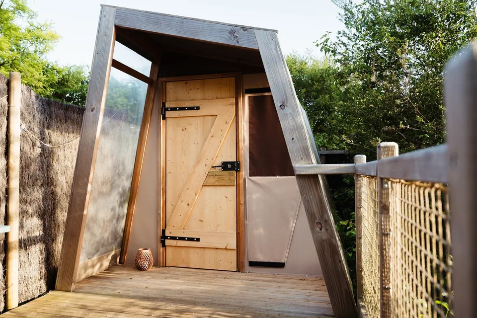 L'entrée de la Cabane Tipi et sa terrasse en bois.