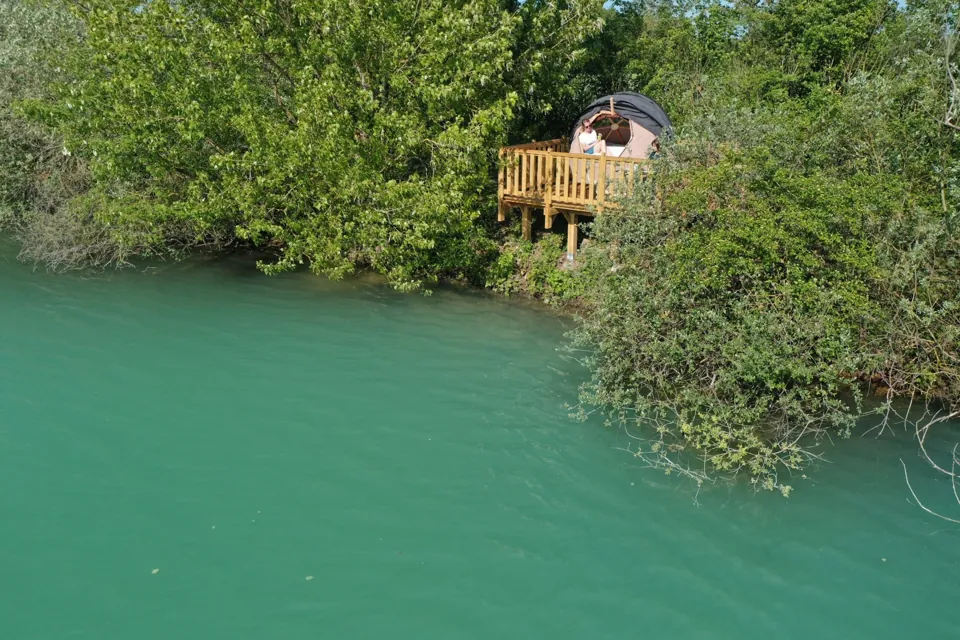La bulle sur pilotis et sa terrasse, perchée au-dessus de l'eau turquoise.