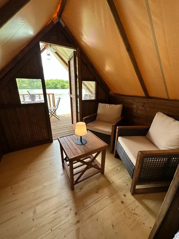 Le coin salon, ouvert sur la terrasse et l'étang.