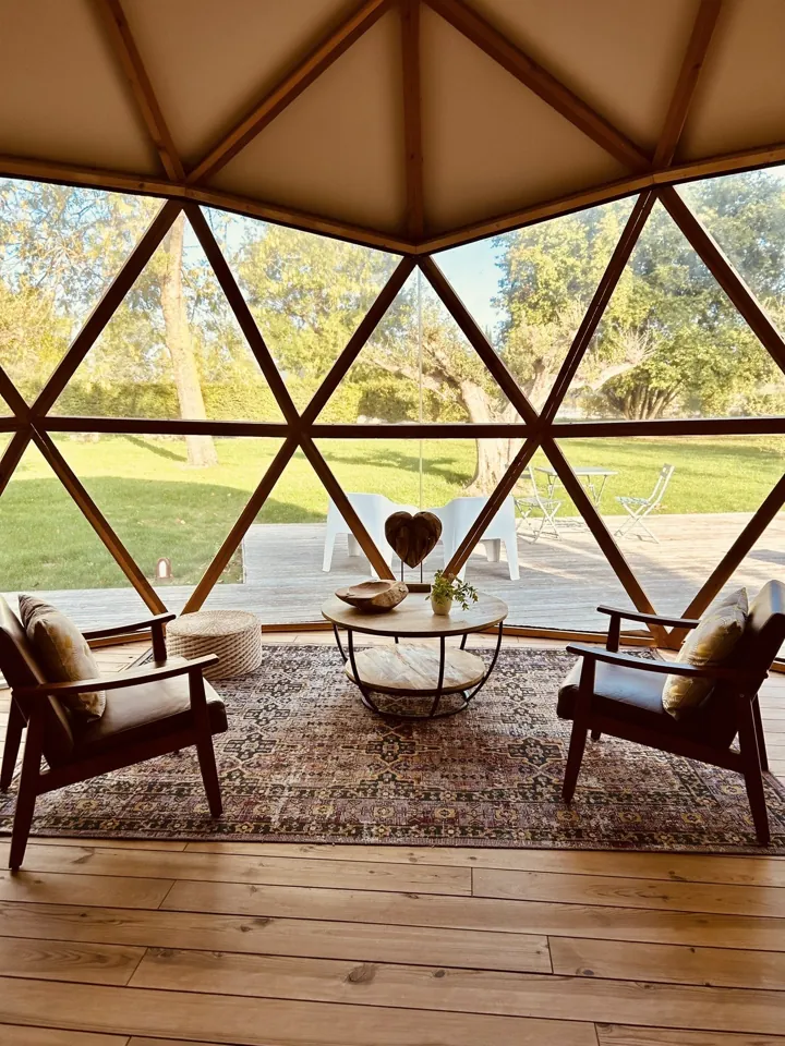 Le coin salon et sa grande paroi vitrée ouverte sur le parc.